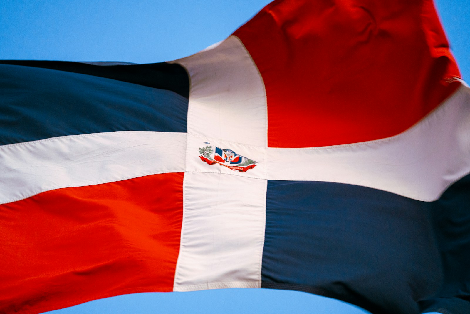 a red white and blue flag flying in the sky